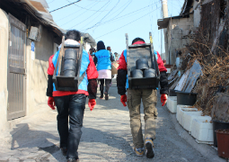 Mitarbeiter tragen 10 kg schwere Säcke mit Kohle auf den Schultern